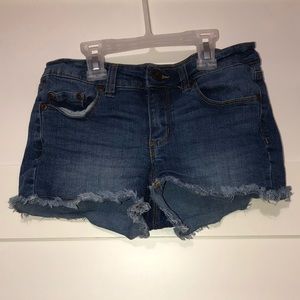Dmedium-dark wash denim shorts with distressed hem